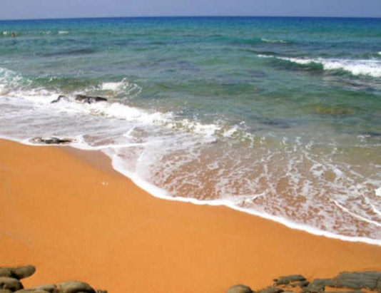 Kokkinos Ammos Beach (Red Sand Beach) near Matala in the south of Crete has course orange-ochre sand that looks red from a distance