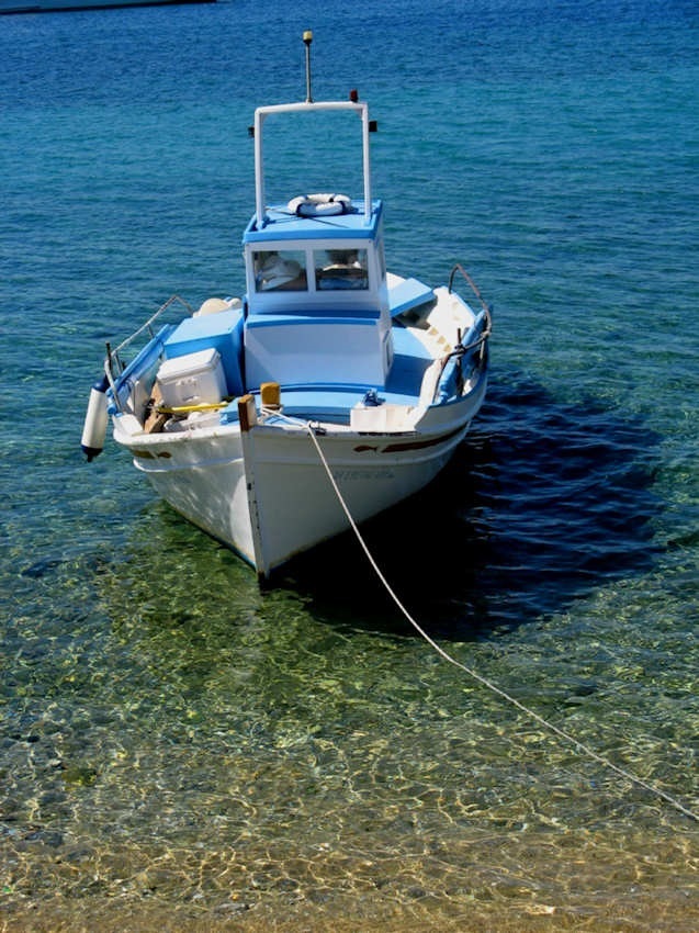 Blue and white wooden fishing boat on perfect crystal clear sea, Mykonos