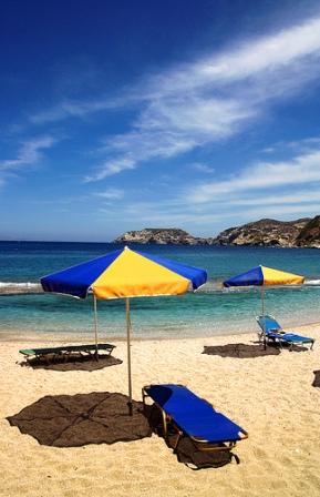 One of the most stunning and characteristic little coves on Crete - bright umbrellas and pretty bay (Image by Micael Goth)