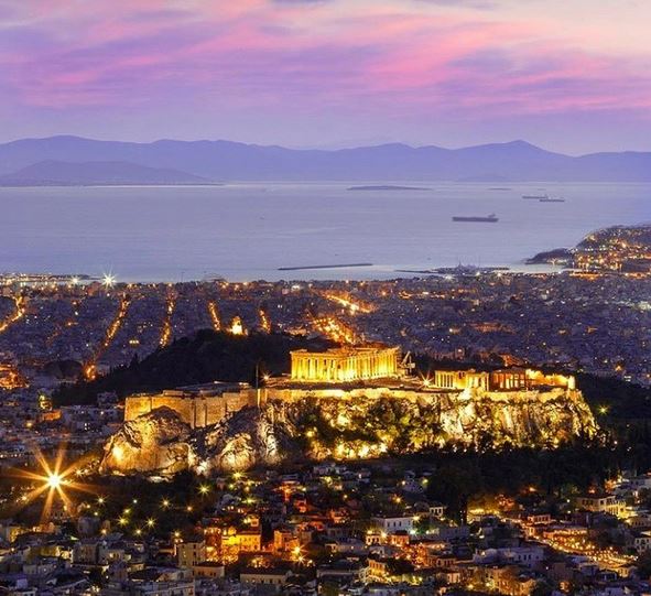 Athens at night, showing the Parthenon lit up on the Acropolis and the view to the harbour