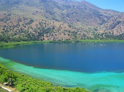 Lake Kournas - bright sand and clear waters show turquoise and blue, ringed by mountains