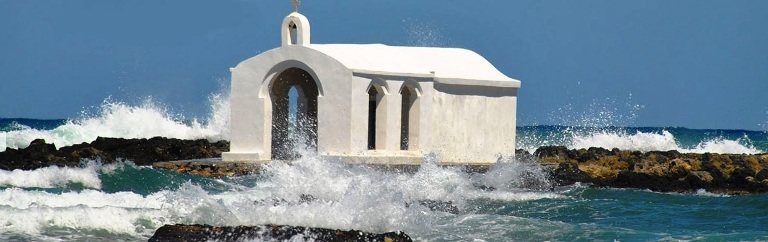 The sea surrounds the chapel at Georgioupolis Beach