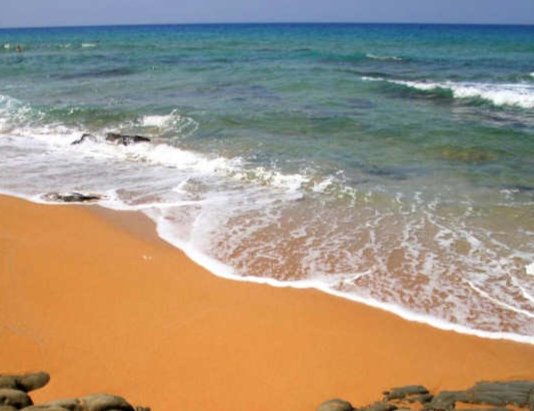 Kokkinos Ammos Beach (Red Sand Beach) near Matala in the south of Crete has course orange-ochre sand that looks red from a distance