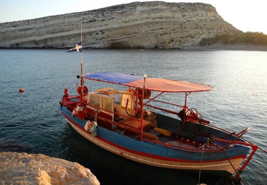 Matala bay and caves with fishing boat (image by Mark Latter)