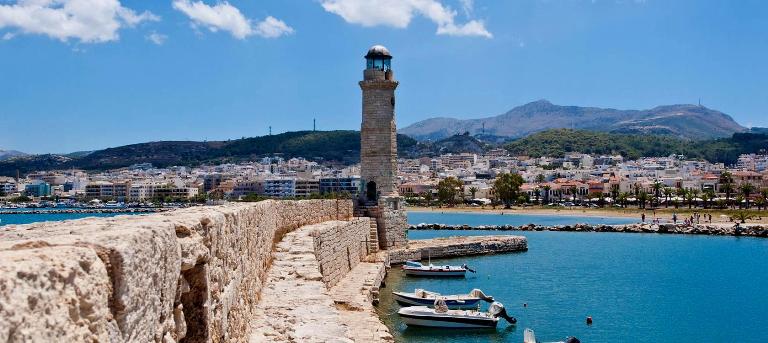 Rethymnon Crete - the walls of the old harbour with the Venetian lighthouse, looking to the west to the beach